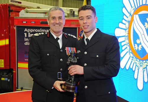 Chief Fire Officer Phil Garrigan presents the 'Top Recruit' award to Leon Lewis